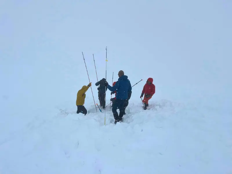 Emberek lavinamentési gyakorlatot tartanak a ködös, havas magashegyen